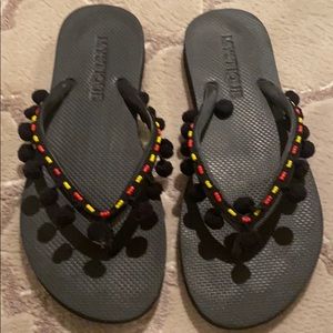 Black pom pom flip flops